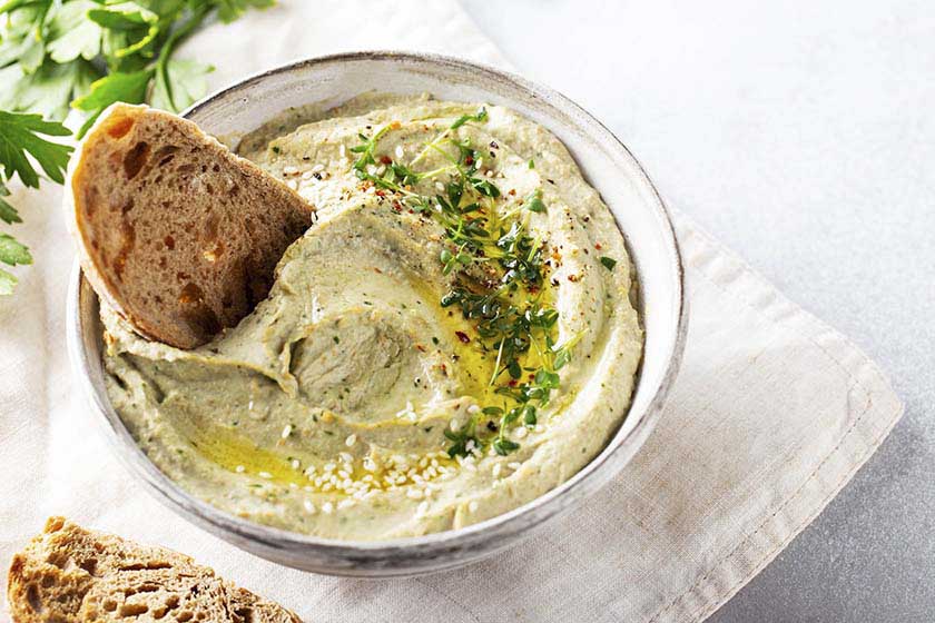 Bowl of Baba Ghanoush with bread on table