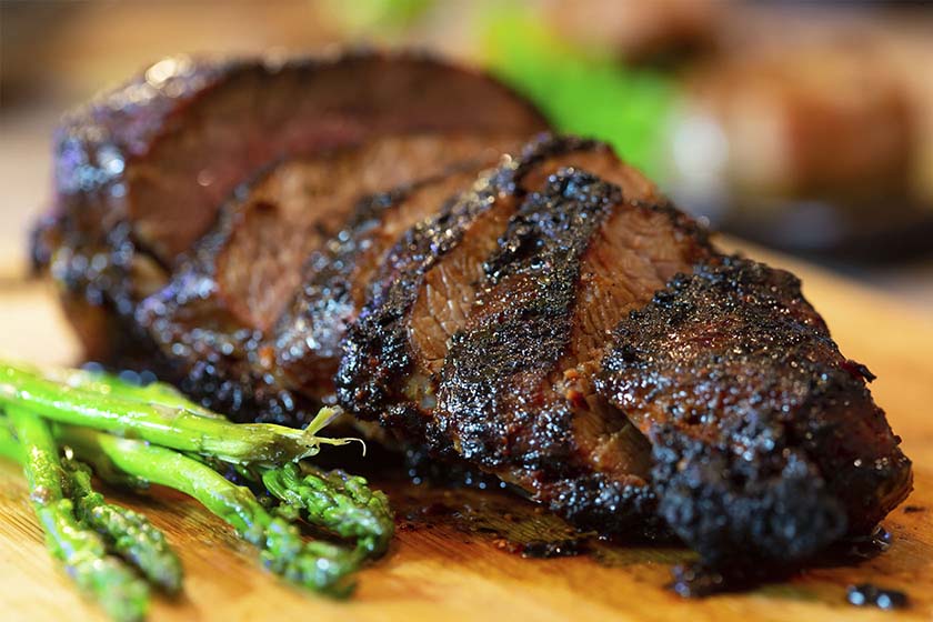 Juicy bourbon glazed tri tip steak served with steamed asparagus