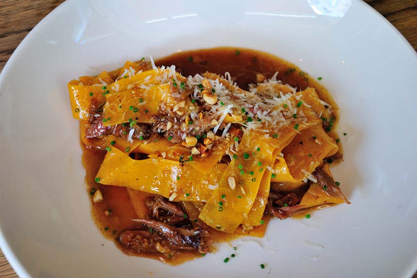 Bowl of wide Pappardelle pasta in a rich duck ragu sauce