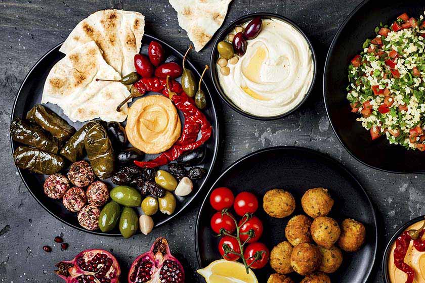 A traditional Mezze platter surrounded by other traditional Mediterranean foods