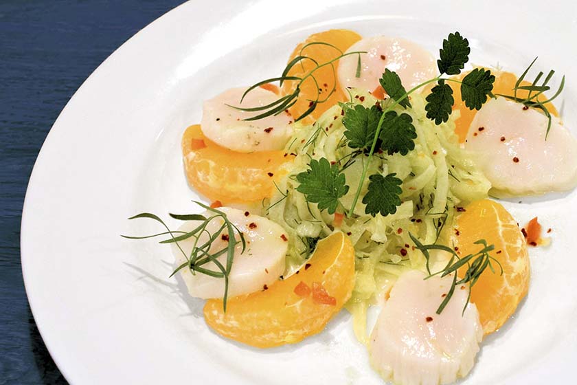Plate of scallop ceviche with fennel, tangerine slices and tarragon