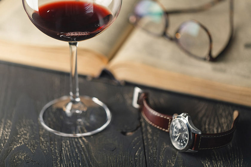 Glass of Syrah wine with book, and watch