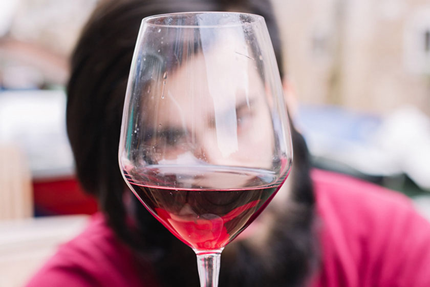 Person looking at color of wine through Sensory Evaluation